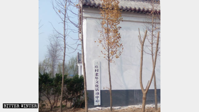 洪山廟外牆被刷成白色，外牆上掛著老年活動中心的牌子