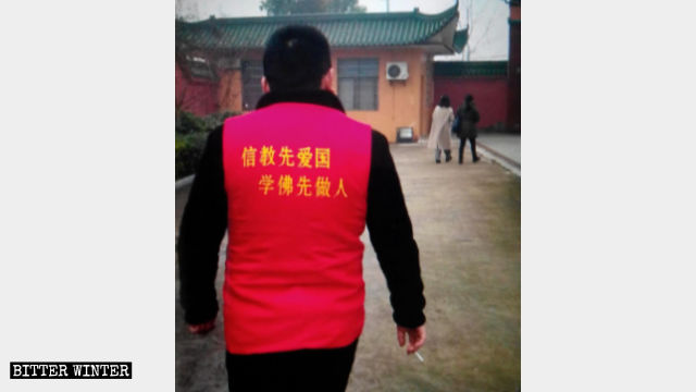 義工的馬夾背後寫著「信教先愛國 學佛先做人」 義工的馬夾背後寫著「信教先愛國 學佛先做人」