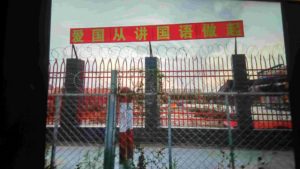 學校圍牆上安裝鐵絲網，掛著「愛國從講國語做起」的標語（知情人提供）