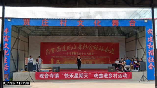 賈莊村文化戲台正在演出，戲台上掛著「快樂星期天」的橫幅