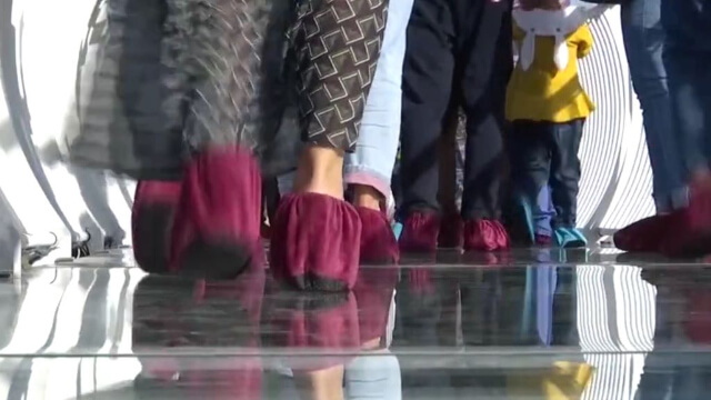 遊客腳穿鞋套走在帶有模擬碎裂音效的玻璃上。