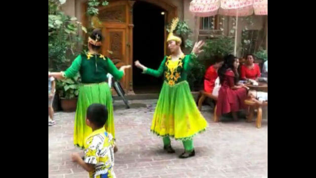 維吾爾女孩被迫為來喀什旅遊的漢族人跳舞，滿臉的不高興。
