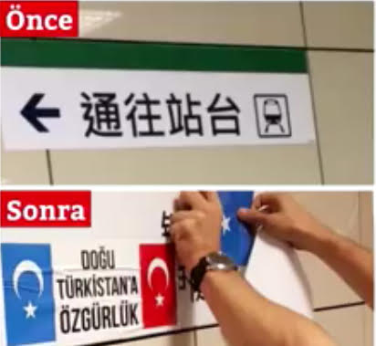 一位支持維吾爾人的土耳其人在通往電車站台的中文指示牌下用膠帶貼上了東突厥斯坦和土耳其的旗幟