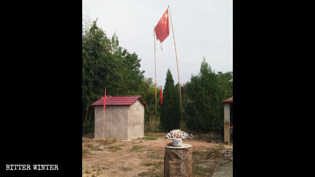 被查封的福林寺外飘着一面破损的国旗