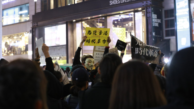 一名示威者在人群中高舉標語牌：「光復香港 時代革命」（知情人提供）