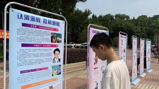 廣東省廣州市某社區內，一少年正在瀏覽反「邪教」宣傳圖片展。（網絡圖片）