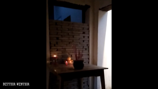 封庙的门边摆放香炉贡品，信徒只能隔墙膜拜