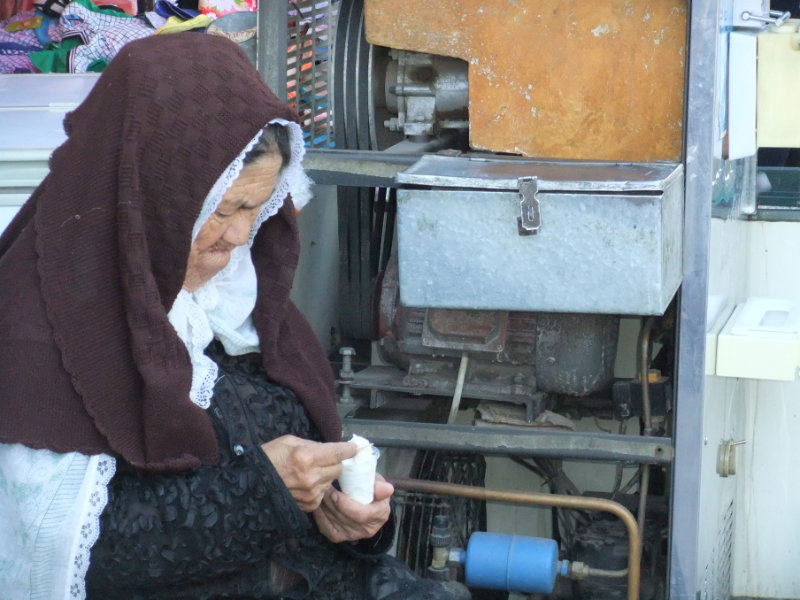 這位婦人在吃自製的冰淇淋，那時她還可以戴有特色的喀什面紗。喀什　2012年
