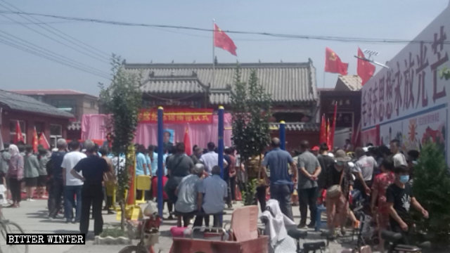 花官營村村民聚在毛主席紀念堂外，牆上寫著「毛澤東思想永放光芒」